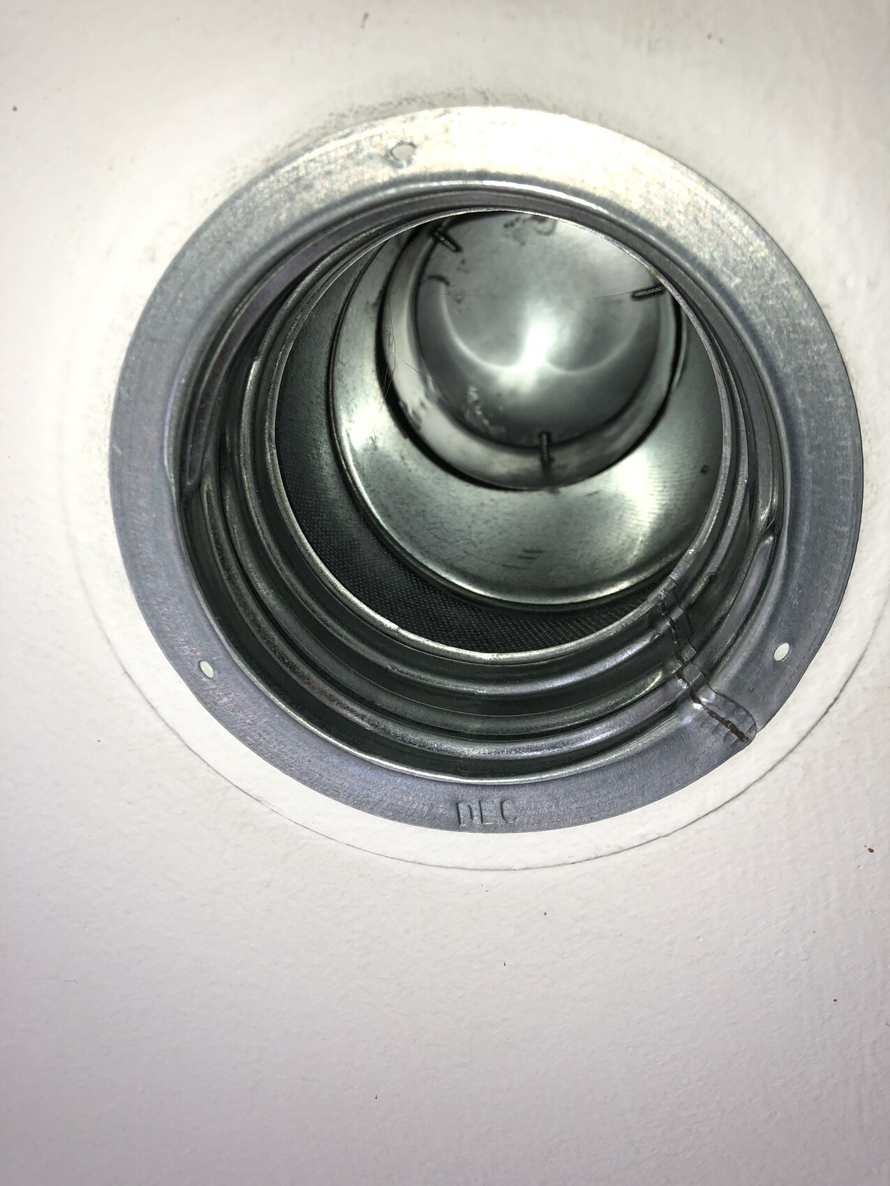 Round metal recessed ceiling light housing in the ceiling opening with inner rings.