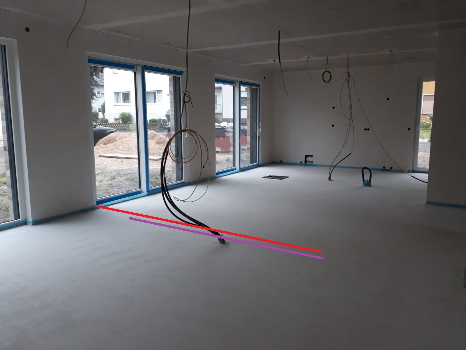 Shell construction: empty interior with exposed cables, large windows, and construction work.