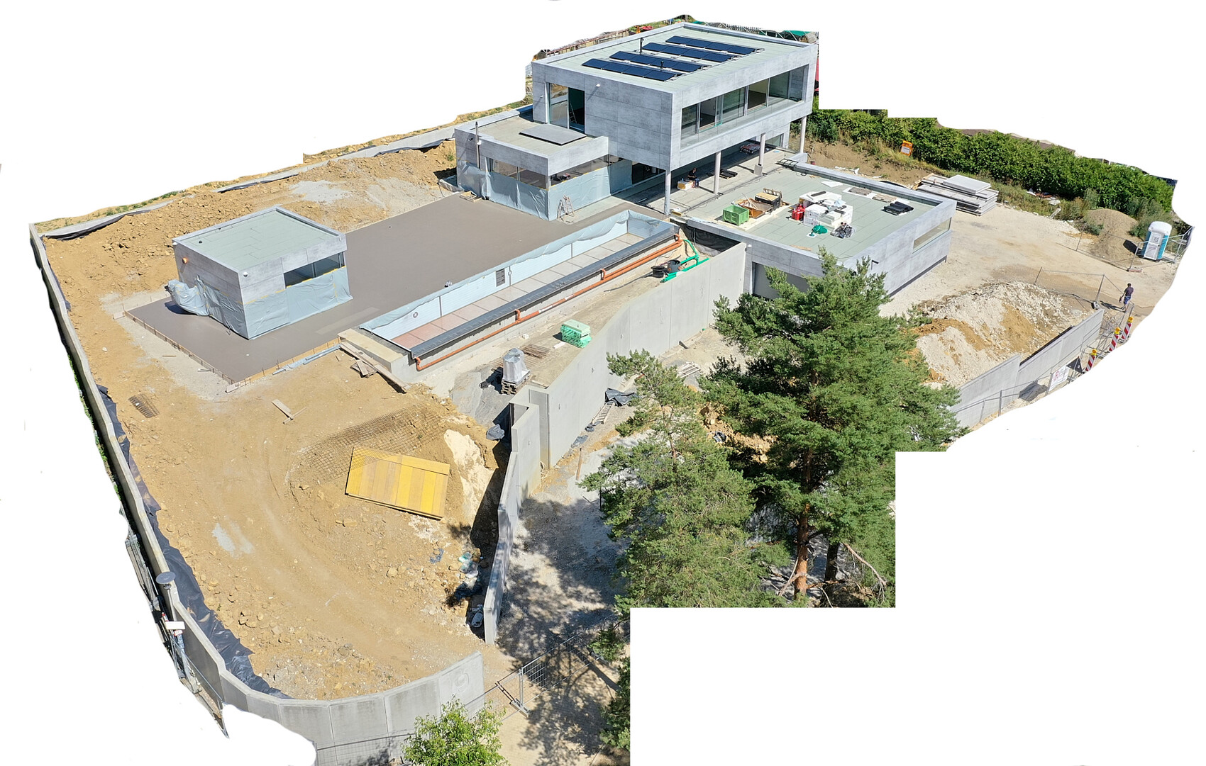 Modern concrete construction site with multi-story building and solar panels on the roof.