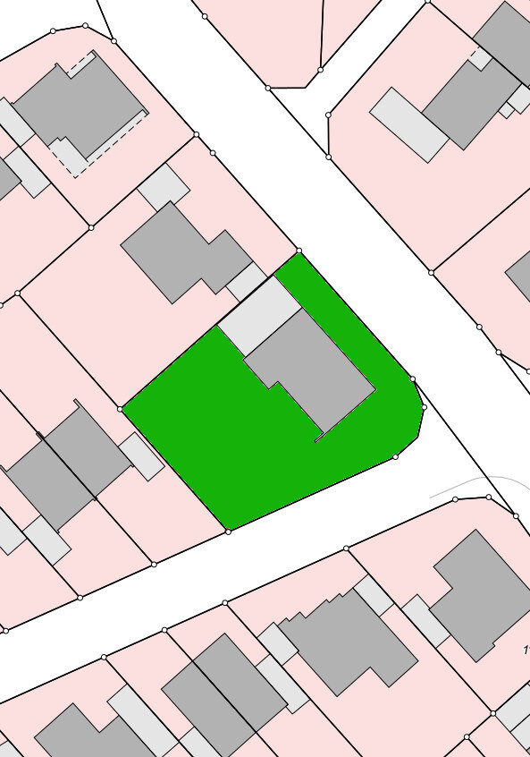 Site plan of a settlement: green plot with gray building, surrounding pink houses.