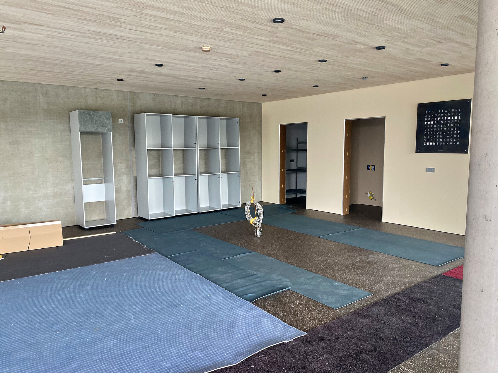 Unfinished interior with white shelves, floor mats, and a wire spiral in the center.