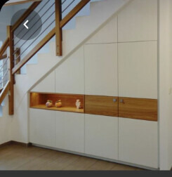 Modern white built-in cabinets with wood accent in bright interior.