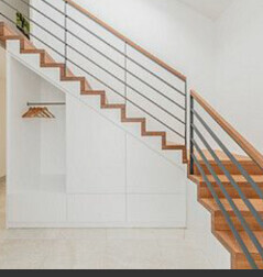White interior staircase with wooden handrail and storage space under the stairs