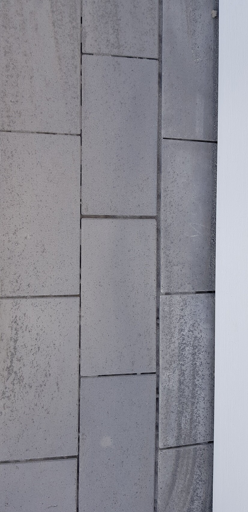 Close-up of gray concrete or stone slabs in a vertical wall with joints.