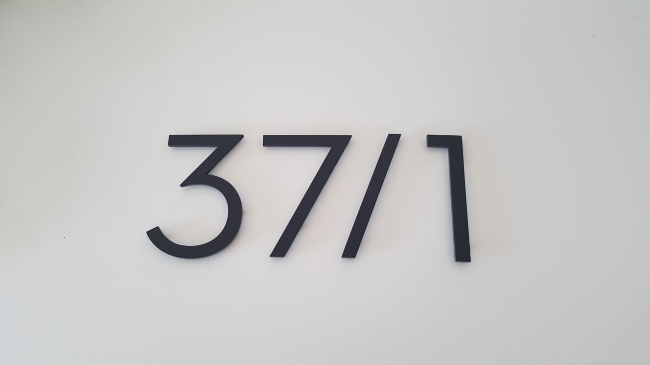 Black numbers 3771 as wall decoration on white background.