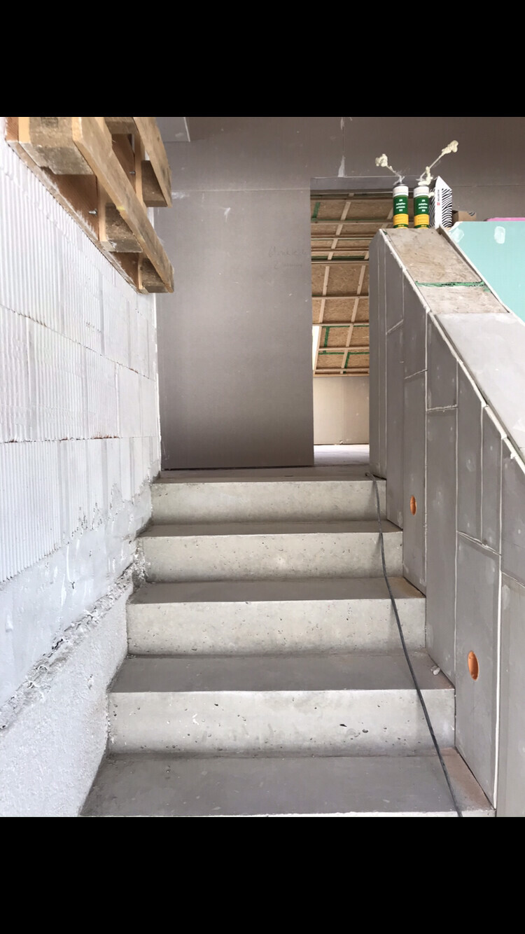Construction site: interior concrete steps, unfinished walls, cables at the edge