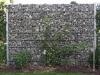 Gray stone garden wall used as a boundary and privacy screen outdoors.