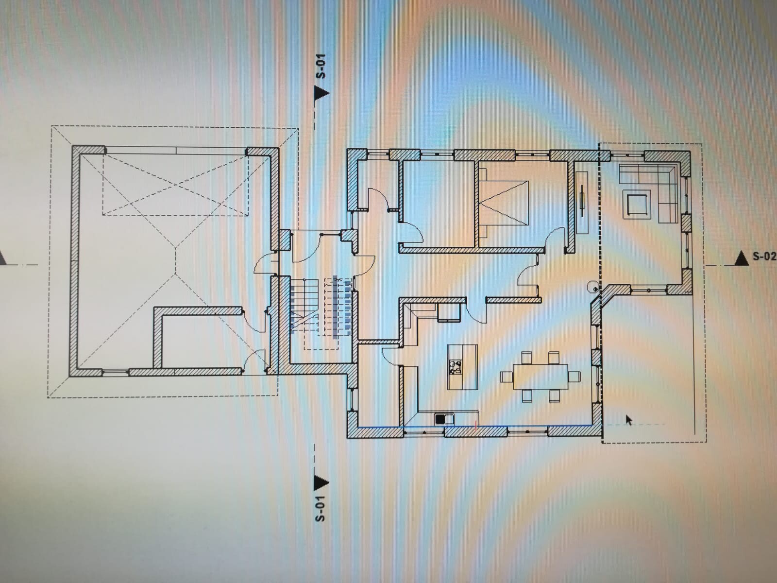 Grundriss eines Wohnhauses mit Wohnzimmer, Küche, Essbereich, Schlafzimmer, Treppe und Garage.
