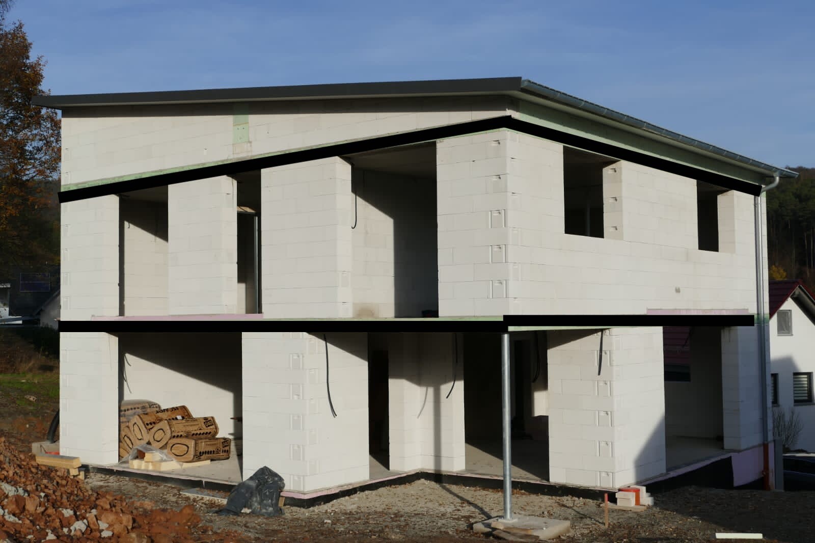 Zweistöckiges Haus im Rohbau aus weißen Blöcken auf einer Baustelle