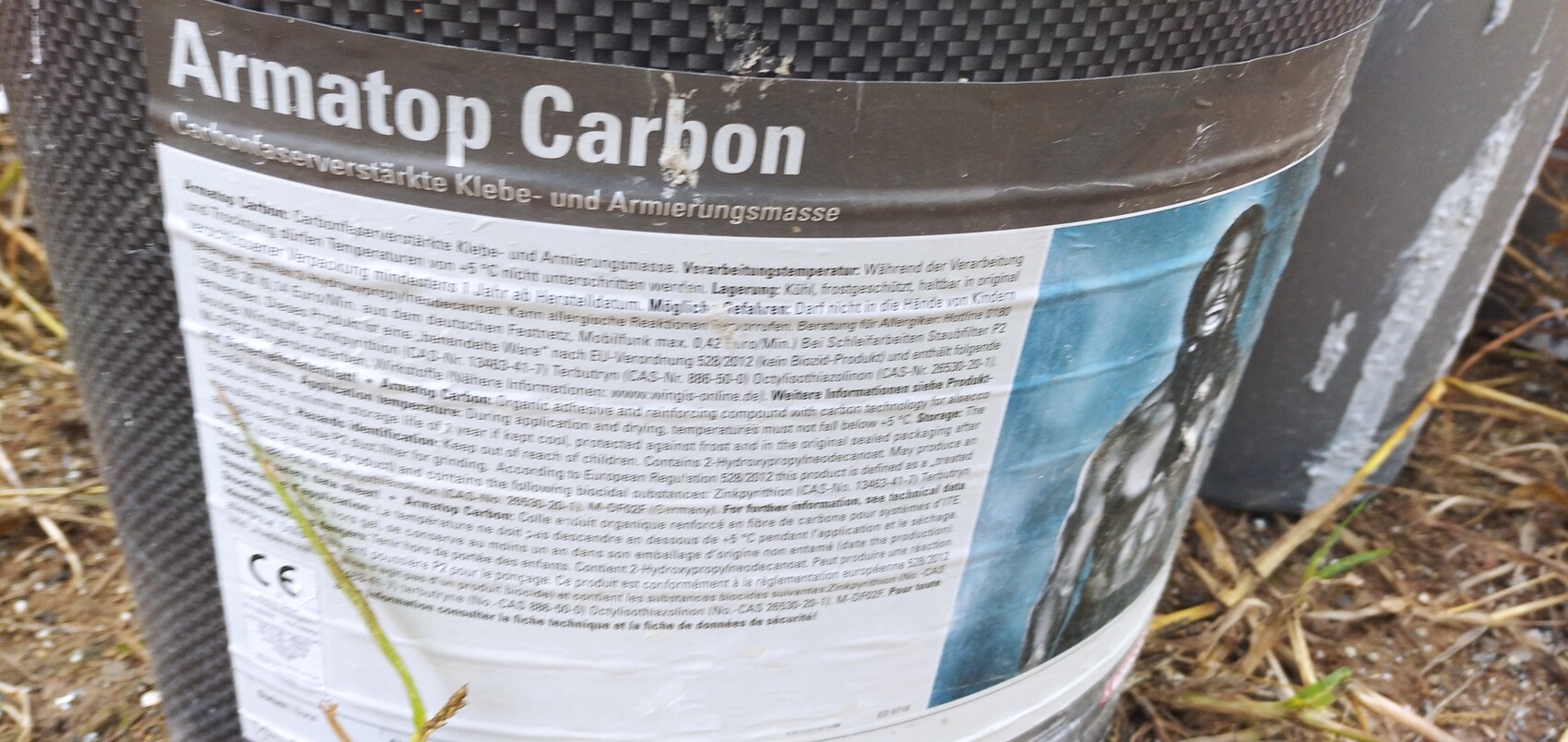 Close-up of a bucket with Armatop Carbon label, adhesive and reinforcement compound