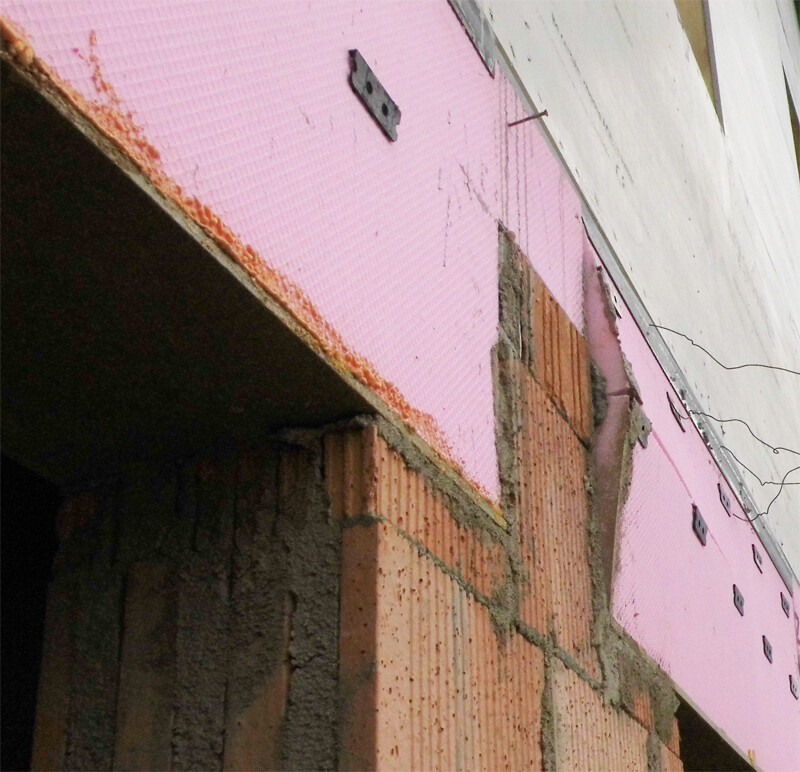 Exterior wall insulation with pink polystyrene boards visible on the shell construction