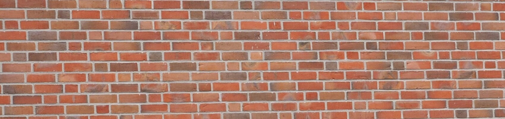 Red brick wall as exterior facade with regular masonry