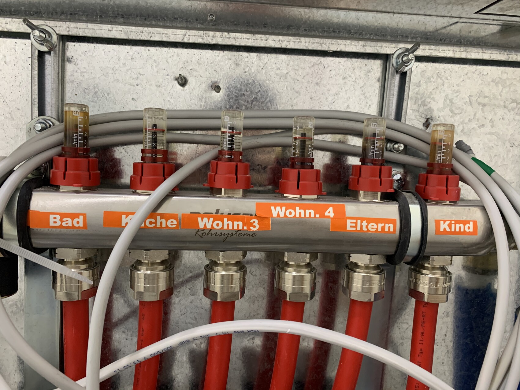Distributor with red connectors and orange-labeled cables: Bathroom, Kitchen, Living room 3/4, Parents, Child.