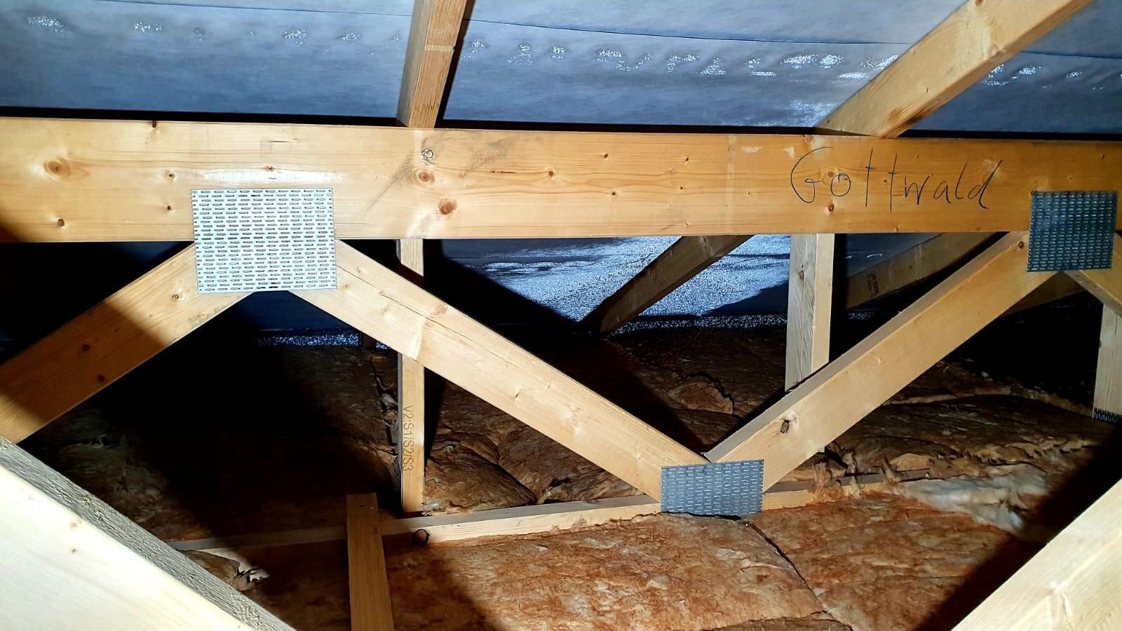 Wood roof frame with rafters, metal plates on joints, visible insulation material; label Gottwald