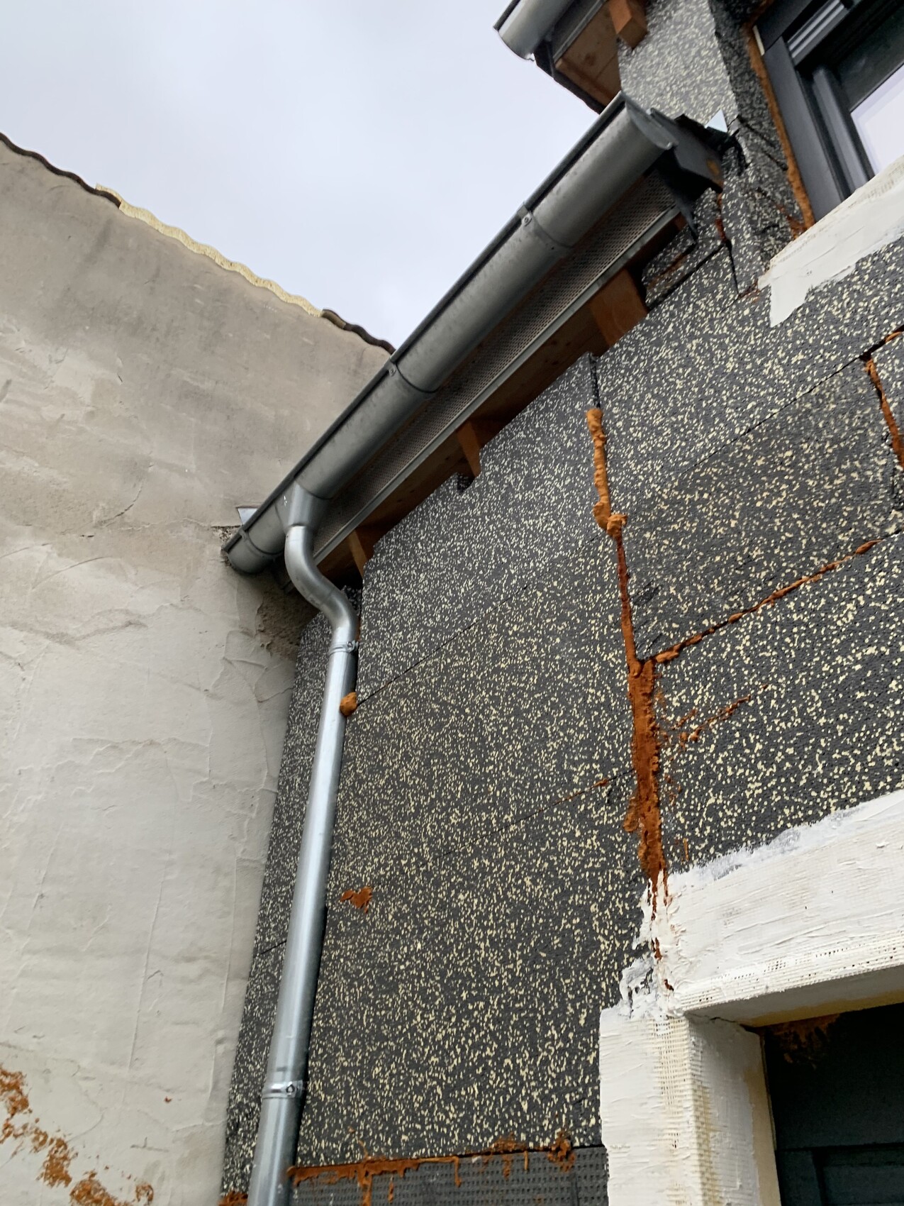 Außenwand eines Gebäudes mit Rostflecken und Rissbildung an der Fassade