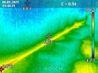 Thermographic image of a building showing temperature differences and a yellow heat conduction line.
