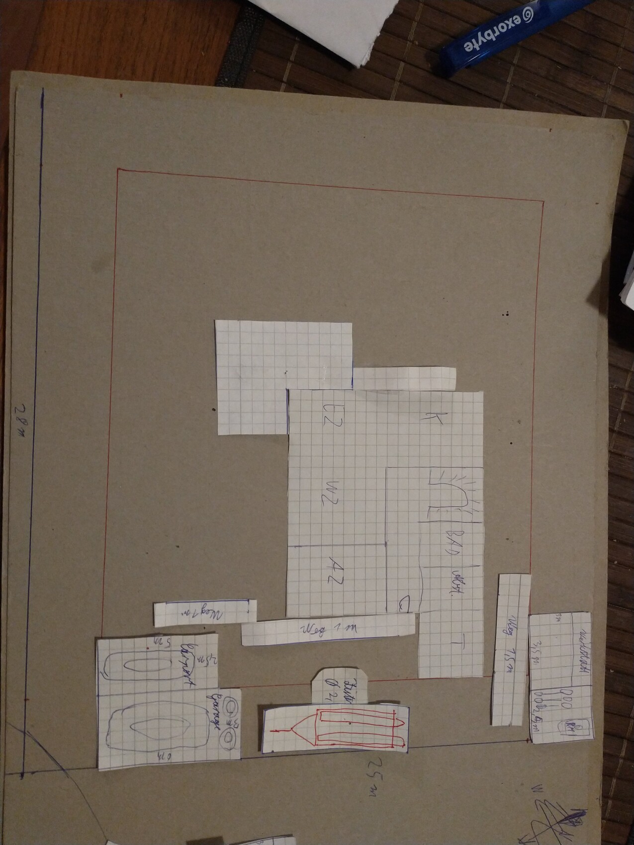 Large cardboard floor model with graph paper pieces as floor plans