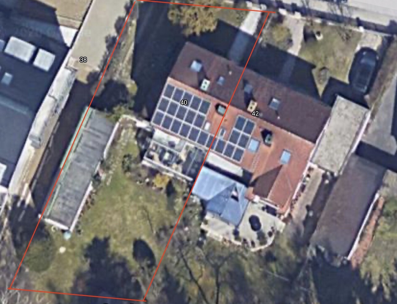 Aerial photo of a house with red tile roof, solar panels and red property boundary.