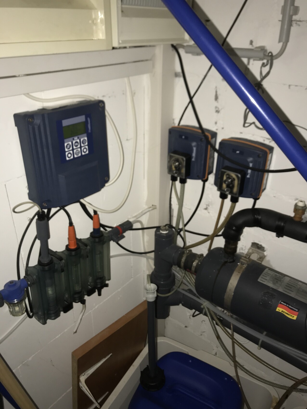 Basement technical area: control unit, several dosing pumps, pipes and a large pump.