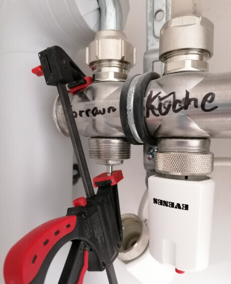 Under the sink: pipes, two shut-off valves, and a measuring device.