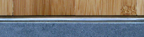 Close-up of wood cladding, metal strip and concrete foundation