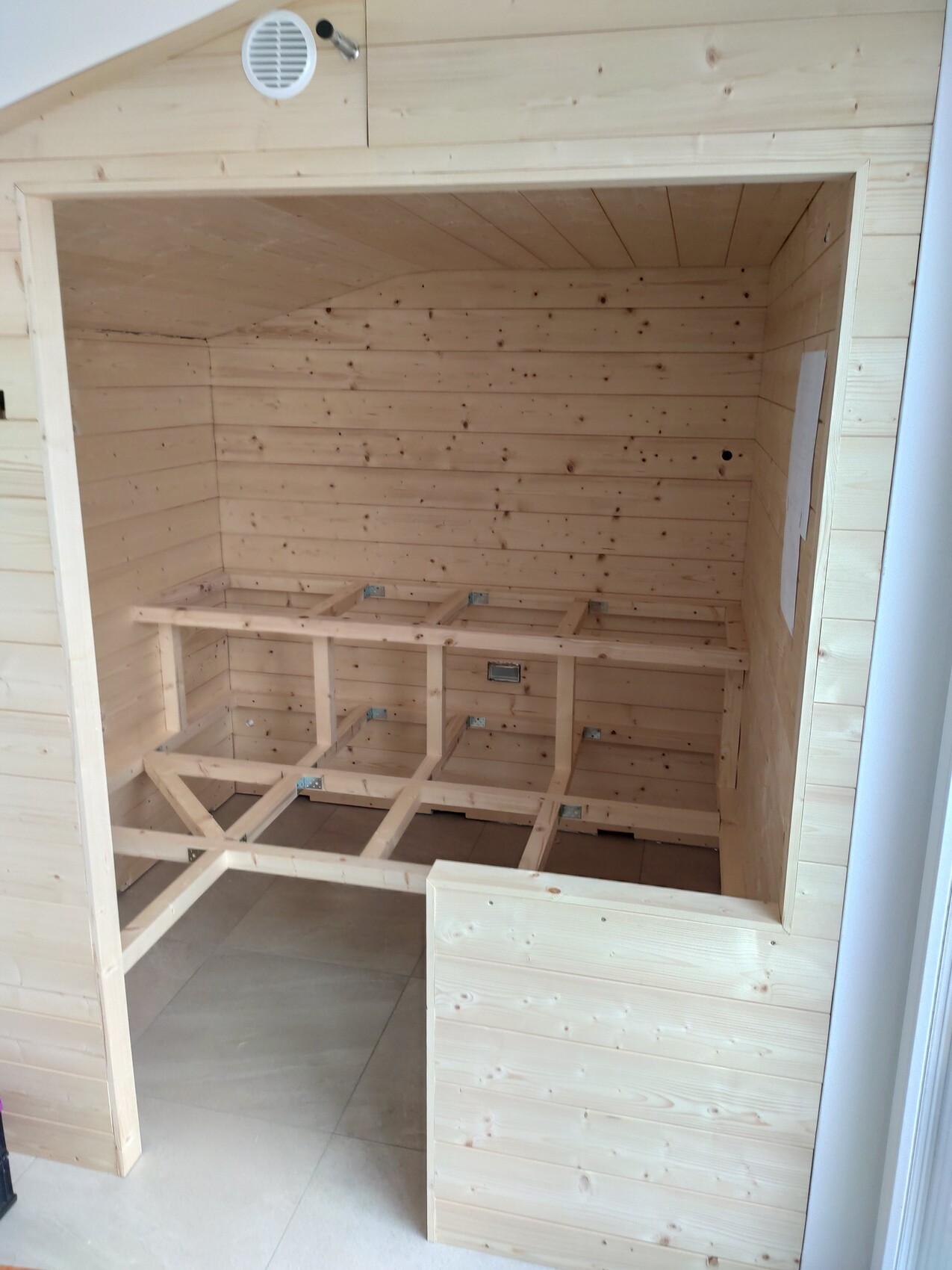Bright wooden sauna interior with unfinished wooden bench frames made of wooden beams