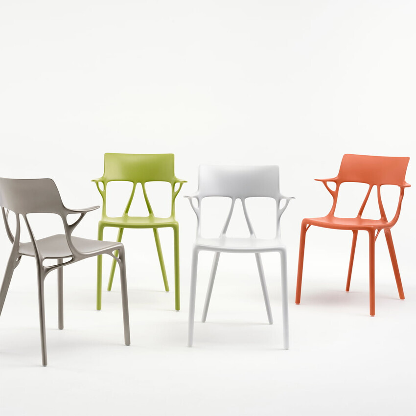 Four modern plastic chairs in gray, green, white, and orange standing on a white background.