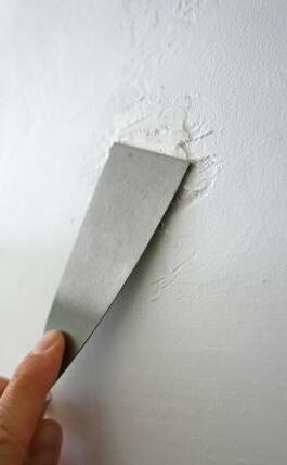 Hand smoothing filler on a wall during renovation