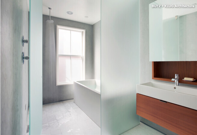 Modern bathroom with bathtub by the window, shower on the left, wooden vanity on the right.