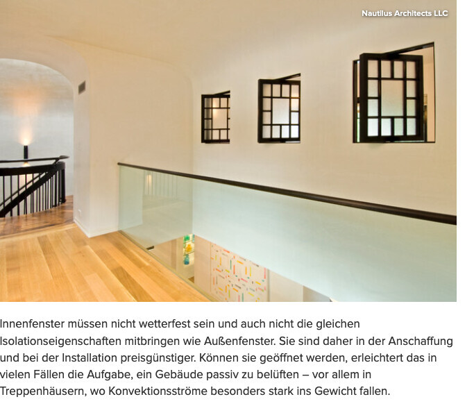 Bright interior with wooden floor, glass railing, and three dark window frames on the wall.