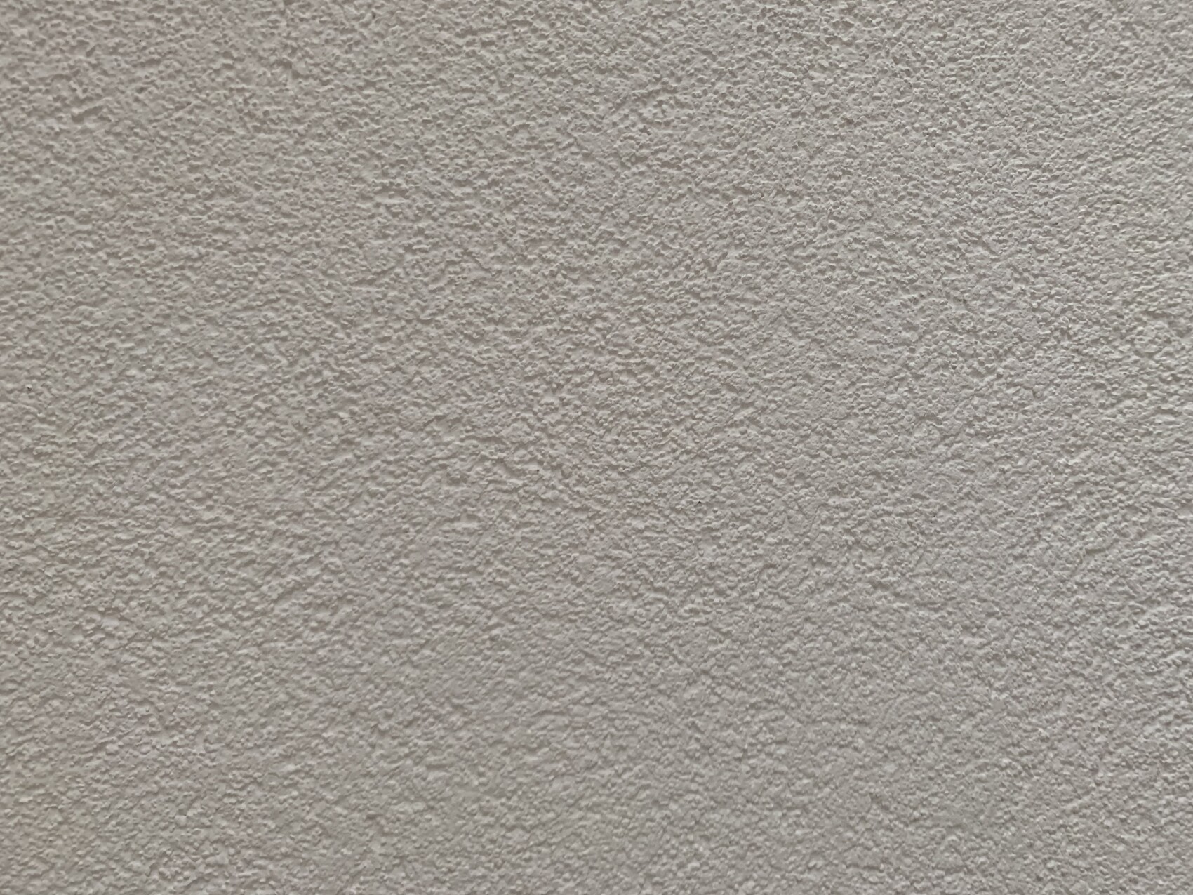 Beige plaster wall with rough texture.