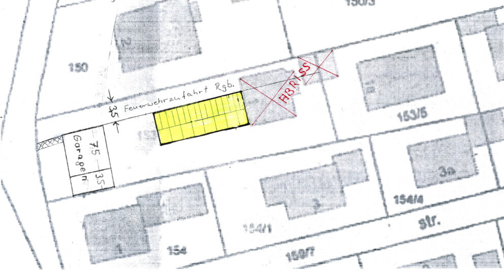 Site plan of a building plot with yellow marked building area and access road