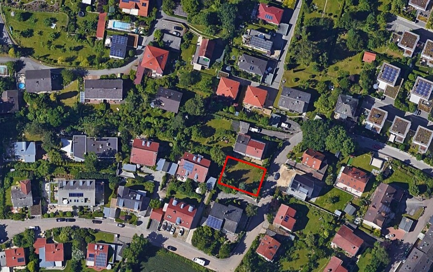 Aerial photo of a residential area; red square marks an undeveloped lot between buildings.