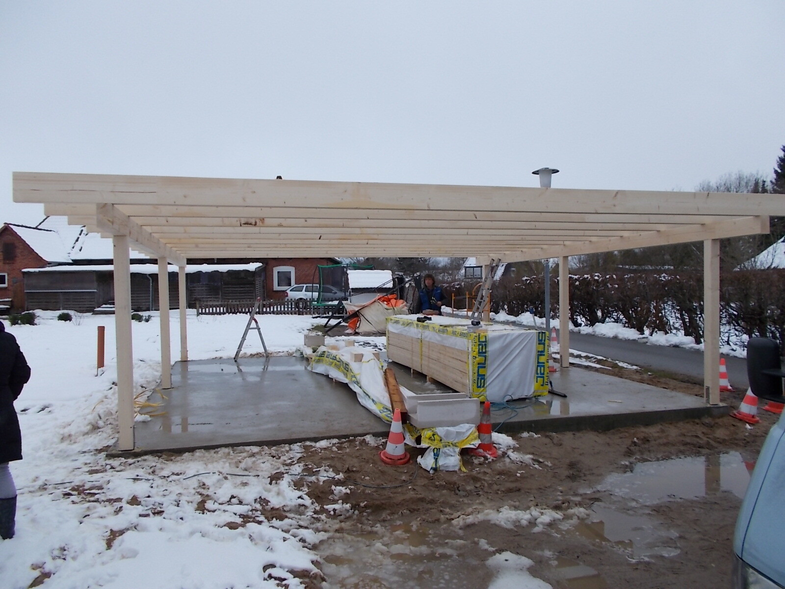 Holzrahmenkonstruktion auf Betonfundament im Winter bei Bauarbeiten im Freien