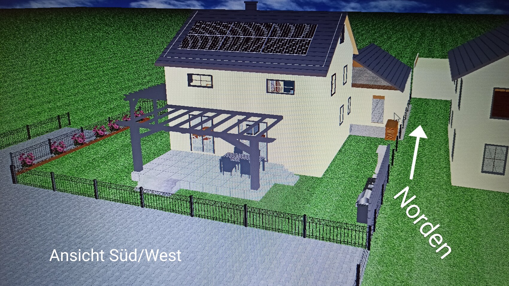 Two-story house with solar panels on the roof, pergola terrace, garden and fence – southwest view.