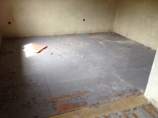 Unfinished basement room with raw concrete floor and unfinished walls