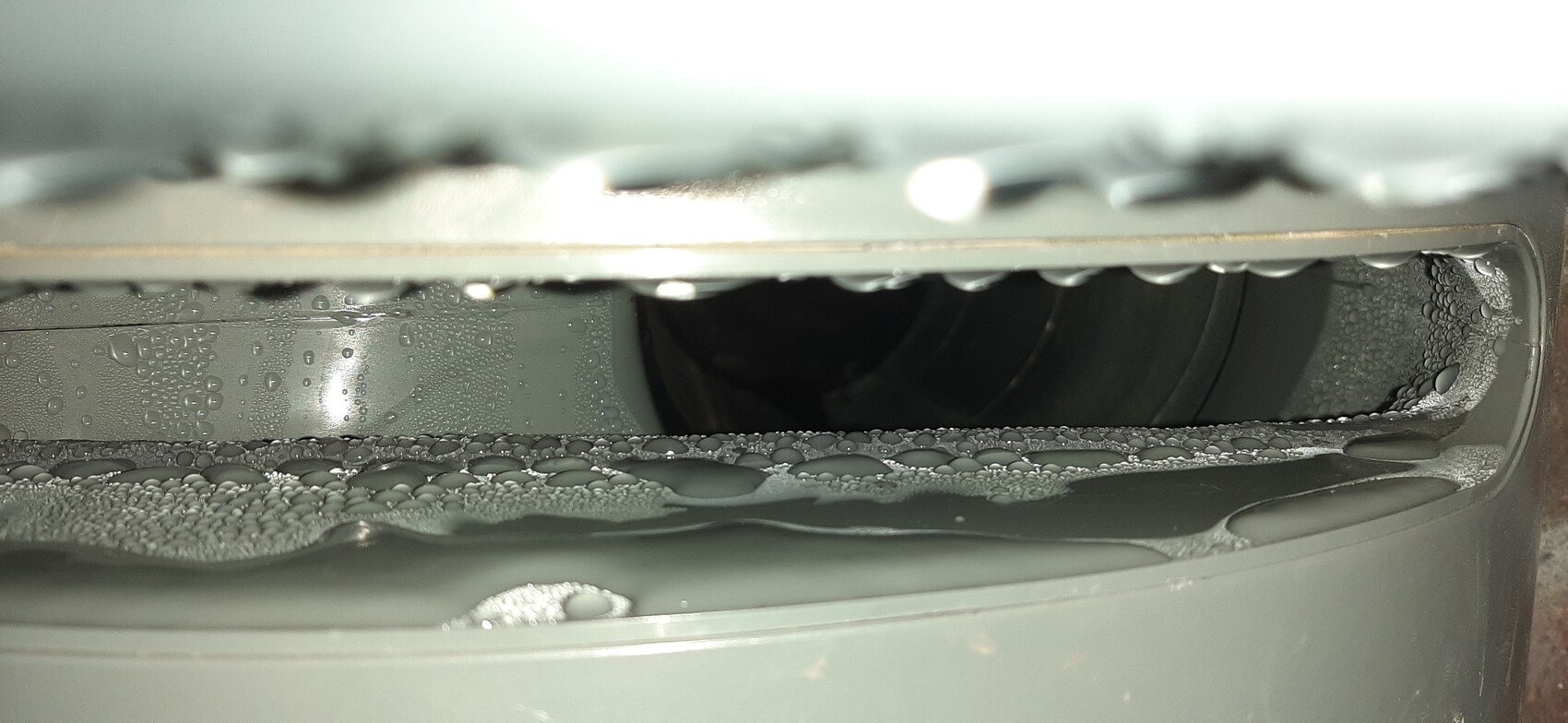 Close-up of the inside of a front-loading washing machine with water droplets and bubbles