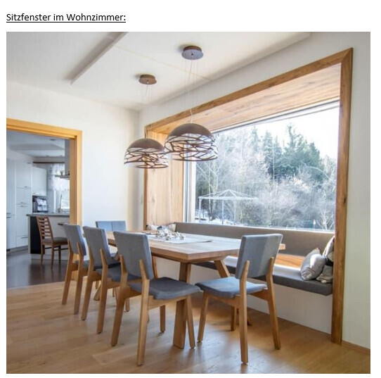 Esszimmer mit langem Holztisch, grauen Stühlen und Fensterbank-Sitzfenster; Pendelleuchten.