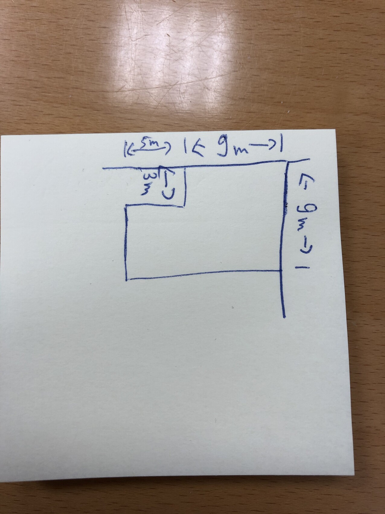 Hand-drawn floor plan of an L-shaped room with an interior recess; external dimensions approx. 9 m.