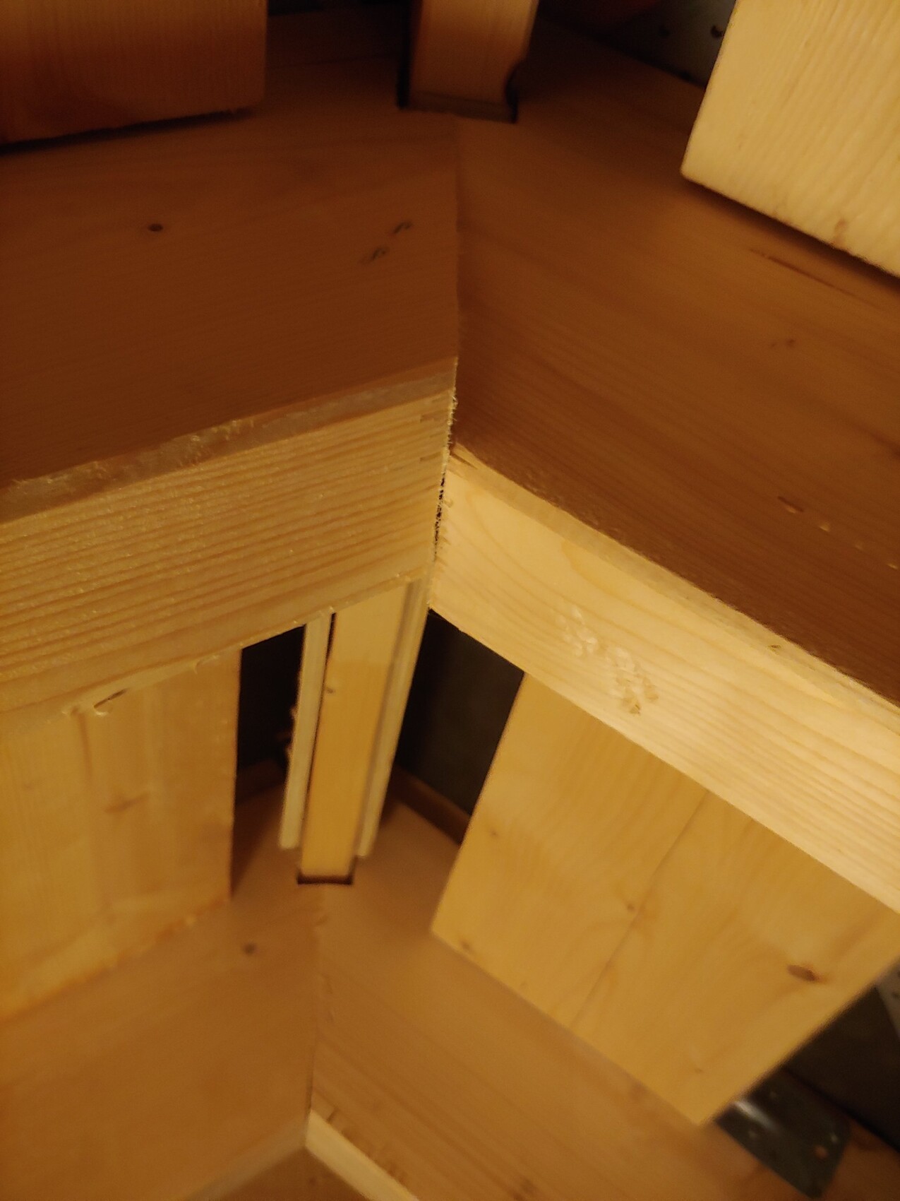 Nahaufnahme von Holzbrettern und Treppenstufen in Innenraum, warmes Licht.