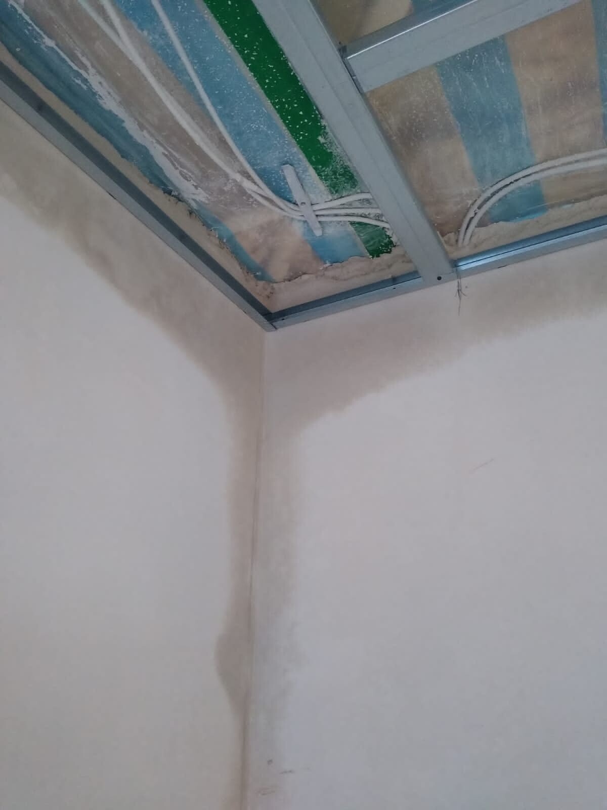 Unfinished interior: metal ceiling frame, loose cables, insulation and plastered walls.