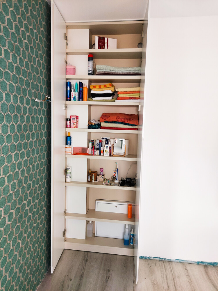 Open bathroom cabinet system with stacked towels and care products