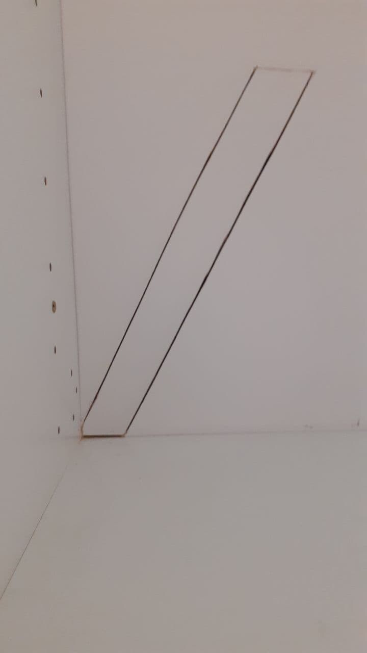 White cabinet inner wall with diagonal narrow strip from bottom left to top right.