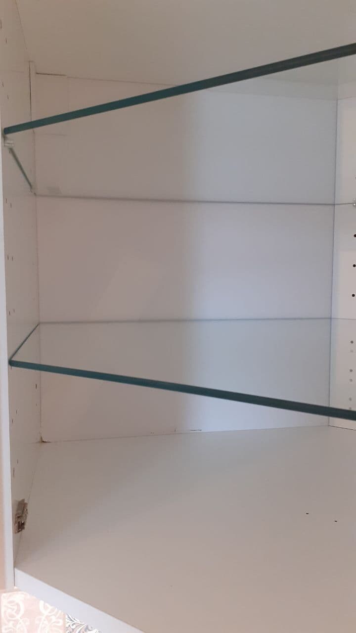 Open white interior of a cabinet with two glass shelves.