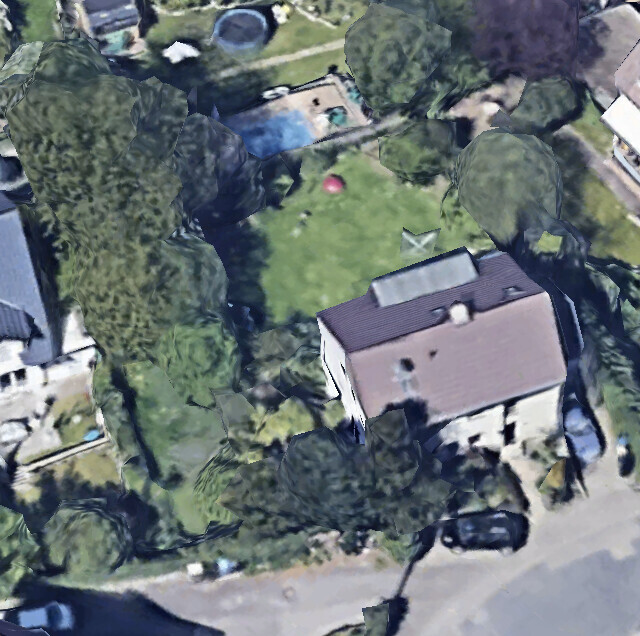 Aerial view of a house with garden, pool in the background, surrounded by trees and a car parked in front.