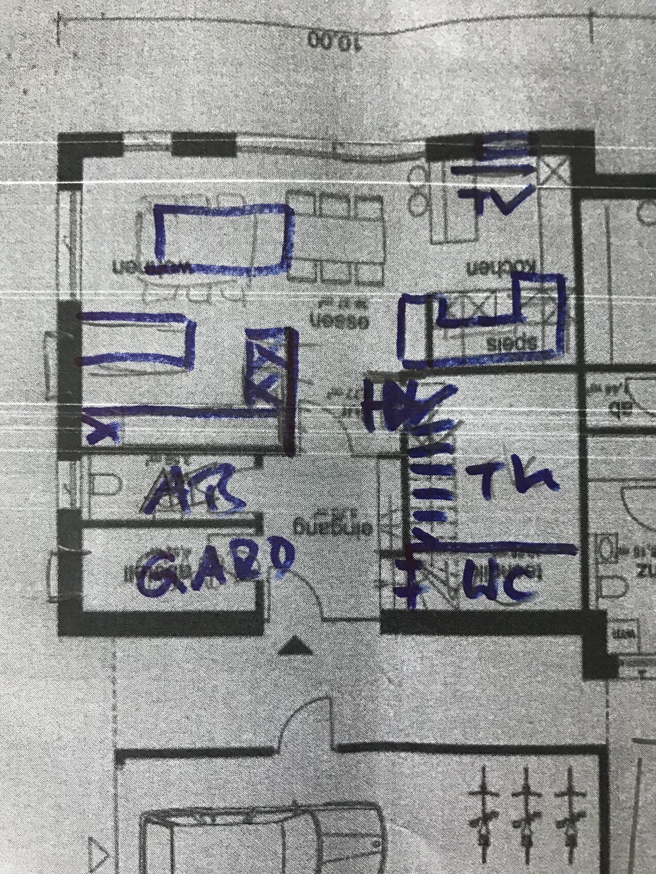 Floor plan of a house with blue handwriting, marked rooms such as living room, corridor, kitchen, WC, wardrobe.