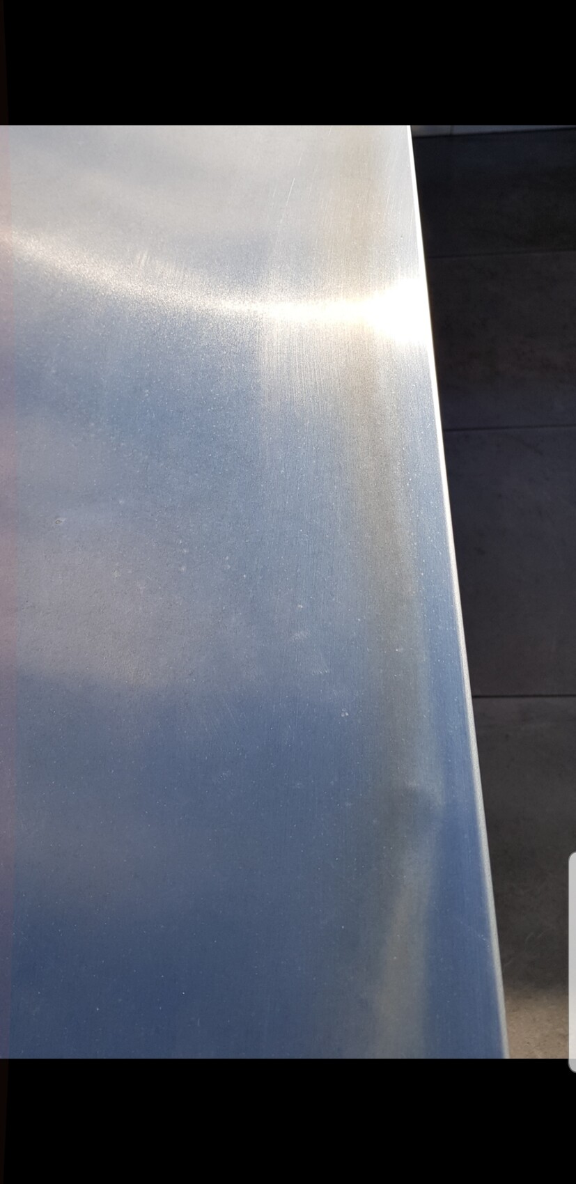 Close-up of a silver metal surface with slight texture and light reflections.