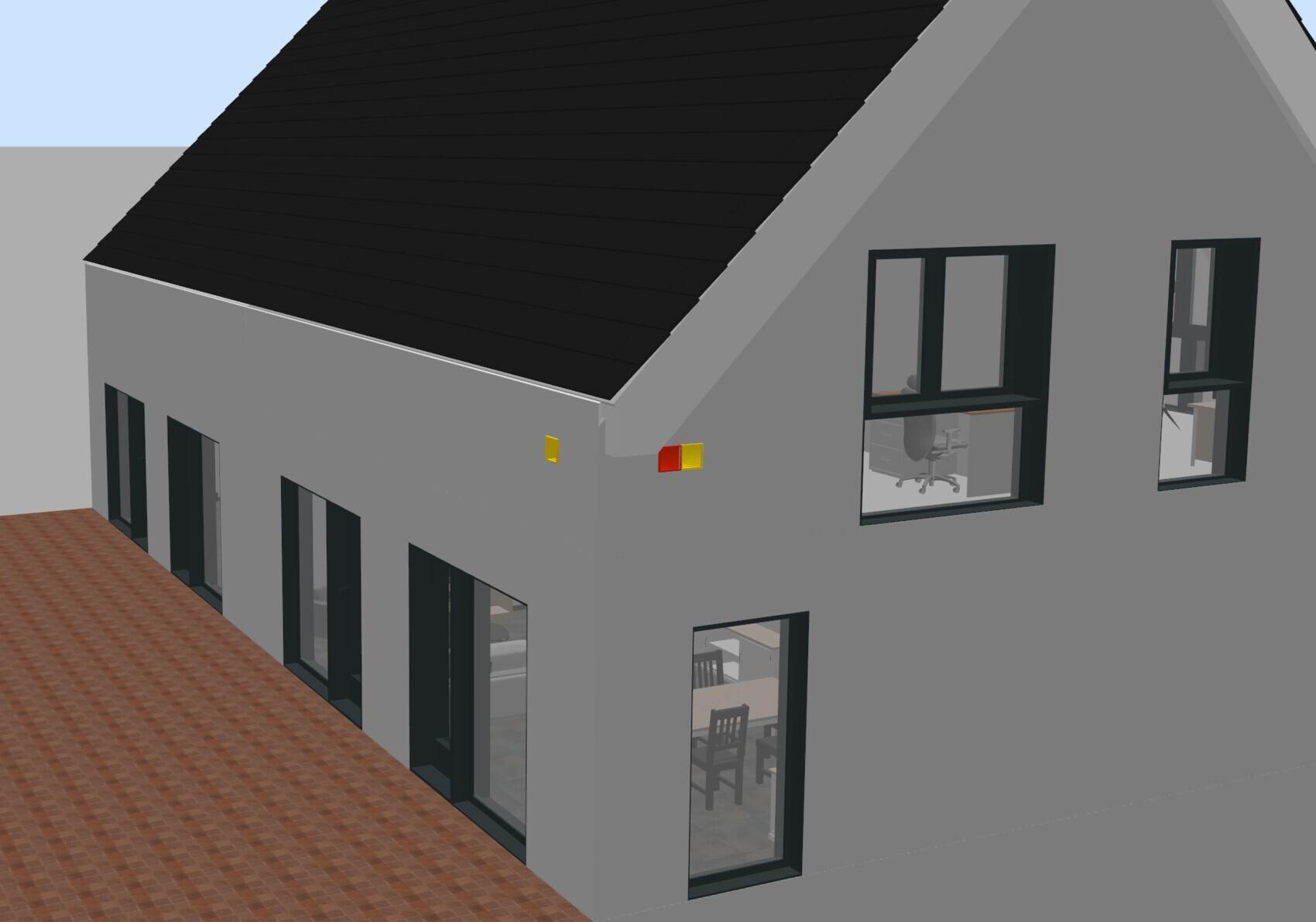 Modern gray building facade with black pitched roof and large windows; interiors visible.
