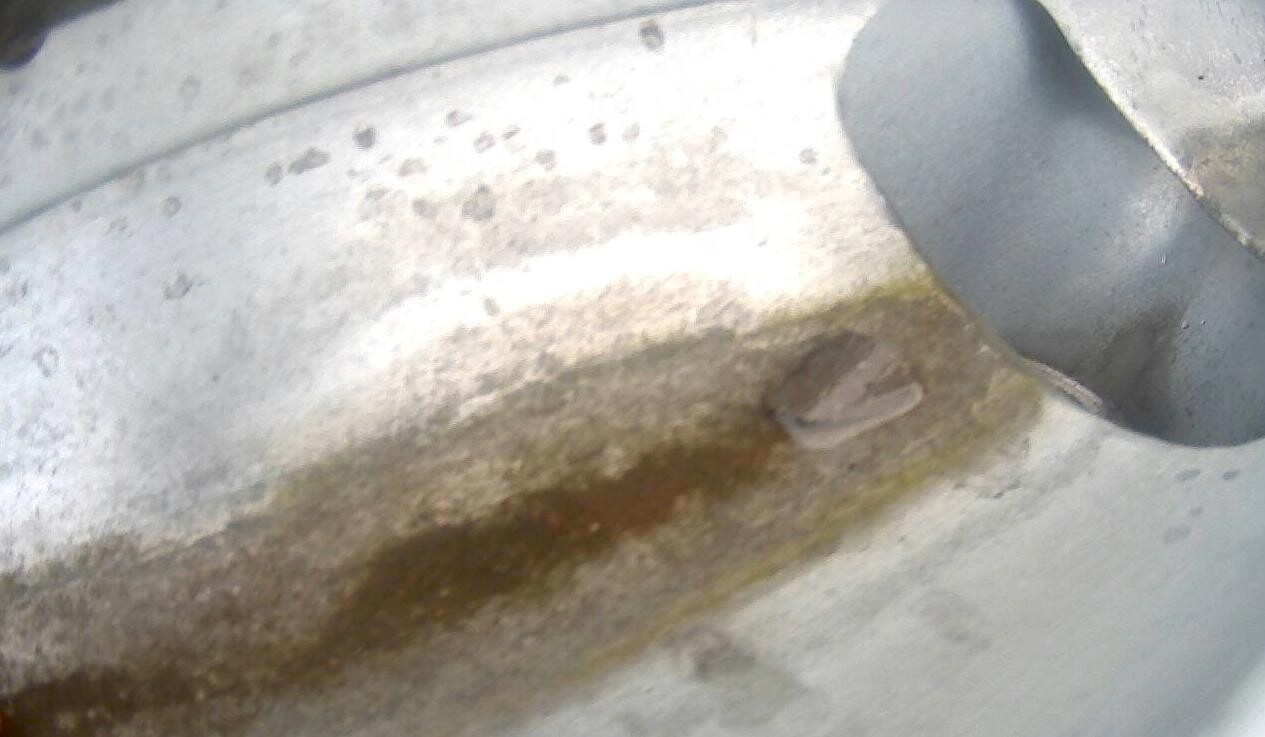 Close-up of a rusty metal surface with brown spots and corrosion