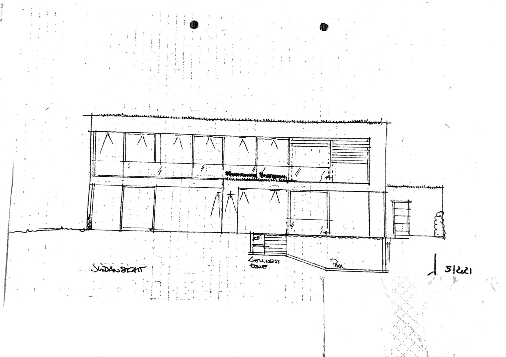 Modern two-story building facade with many windows, balconies, and pool in the foreground